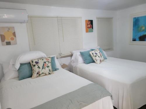 Duas camas num quarto com paredes brancas em Ocean Village at Combate em Cabo Rojo