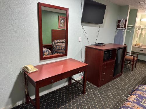 a room with a vanity with a mirror and a desk at Roadside Inn in Floresville