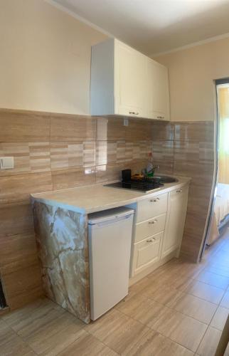 a kitchen with white cabinets and a counter top at Guest House Budva in Budva