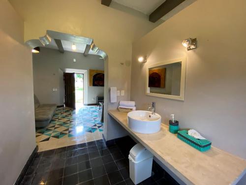 een badkamer met een wastafel en een grote kamer bij Villa en Hacienda noox Kankabal in Cholul