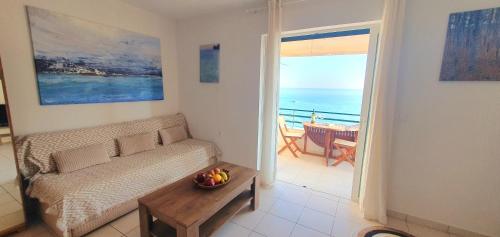 a living room with a couch and a view of the ocean at Glyfada Beach House in Glyfada