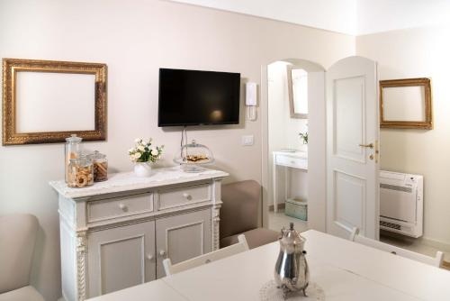 a bathroom with a sink and a tv on the wall at Dimora del Castellano CASA SATURNO in Gioia del Colle