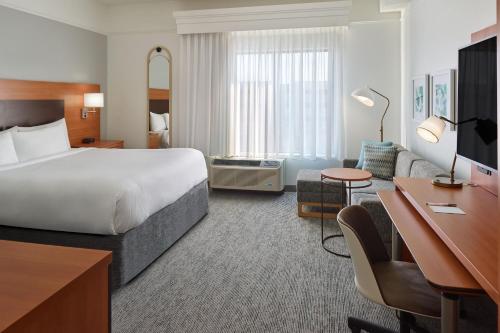a hotel room with a large bed and a desk at TownePlace Suites by Marriott Newnan in Newnan