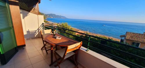 balcone con tavolo, sedie e vista sull'oceano di Glyfada Beach House a Glifada (Glyfada)