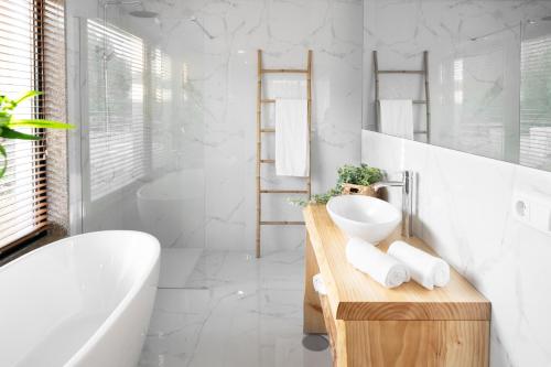 een badkamer met een wit bad, een wastafel en een bad tubermott bij CASA DAS FONTELAS in Castelo de Paiva