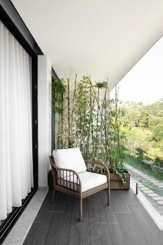 a room with a chair on a balcony with trees at CASA DAS FONTELAS in Castelo de Paiva