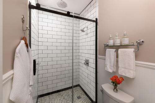a bathroom with a shower with a toilet and towels at Rosemont Inn in Utica