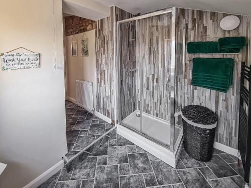 a bathroom with a shower and a trash can at Orchard House in Langrigg