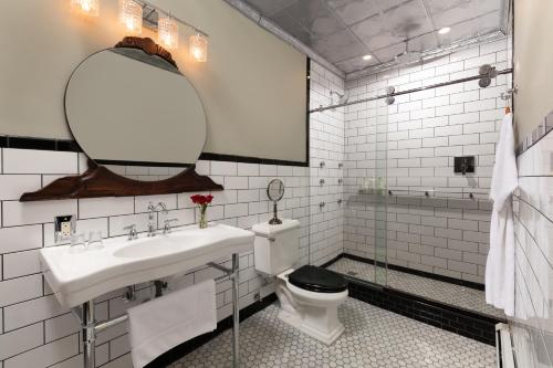 a white bathroom with a sink and a toilet at Rosemont Inn in Utica
