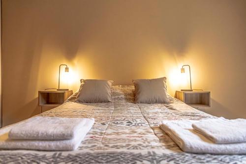 una camera da letto con un grande letto con due lampade sopra di Departamento Moreno Park a Mendoza