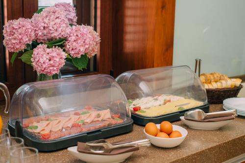 two trays of food on a counter with flowers and eggs at Filip Deluxe Rooms in Kotor
