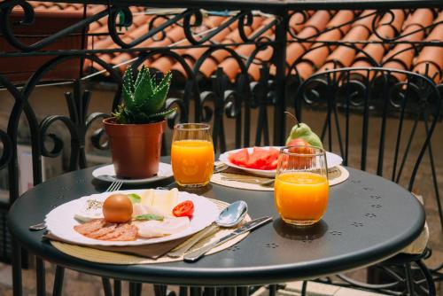 una mesa con dos platos de comida y dos vasos de zumo de naranja en Filip Deluxe Rooms, en Kotor