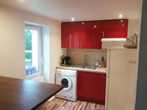 uma cozinha com armários vermelhos e uma máquina de lavar roupa em Appartement 2 Pièces à 5 Minutes des Musées em Grasse
