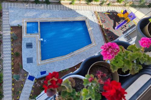un balcón con flores y vistas a la piscina en Прекрасный вид на море, en Mezitli