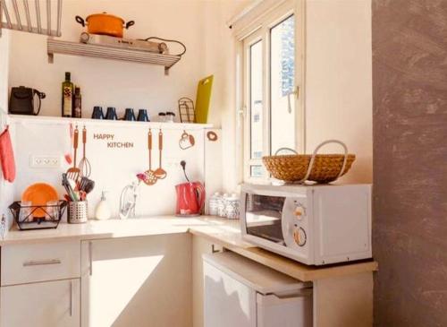 eine Küche mit einer Mikrowelle auf der Theke in der Unterkunft דיזנגוף סנטר חניה פרטית מרפסת שמש in Tel Aviv