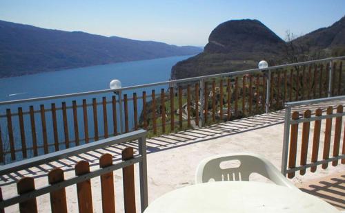 a table and chair on a balcony overlooking a lake at Hotel Panorama e Residence in Tremosine Sul Garda