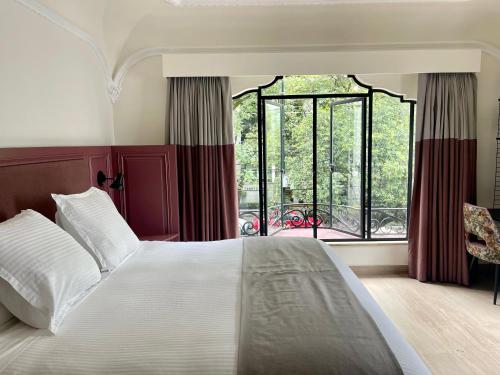 a bedroom with a large bed and a large window at Casa Amari in Mexico City