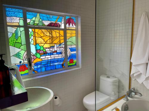 a bathroom with a stained glass window above a toilet at Casa Amari in Mexico City