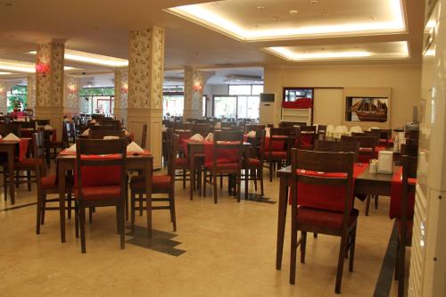 a dining room with tables and chairs in a restaurant at Galeri Resort Hotel - Ultra All Inclusive in Okurcalar