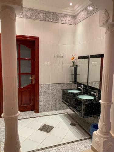 a bathroom with a black sink and a red door at استراحة زين in Al Madinah