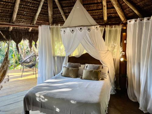 a bedroom with a white bed with a canopy at Jungle Lodge in Abraão