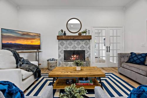 a living room with a table and a fireplace at Remodeled 4 Bedroom Home Close to Downtown Frisco. in Frisco