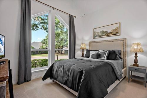 ein Schlafzimmer mit einem Bett und einem großen Fenster in der Unterkunft Remodeled 4 Bedroom Home Close to Downtown Frisco. in Frisco