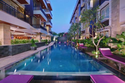 a swimming pool in the middle of a building at Quest San Denpasar by ASTON in Denpasar