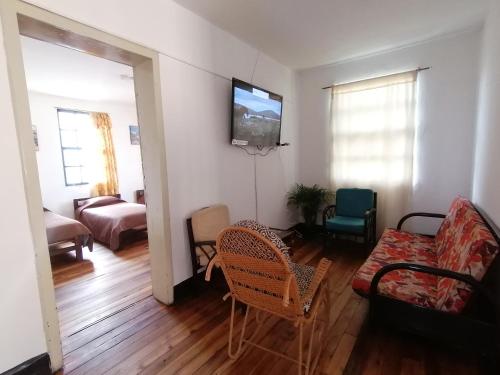 a living room with a television on a wall at Galapagos Natural Life Hostel in Quito
