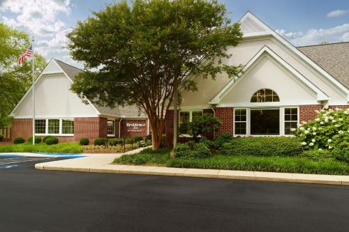 a house with a tree in front of a street at Residence Inn Asheville Biltmore in Asheville