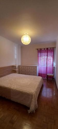 um quarto com uma cama grande e uma janela rosa em Apartamento Tomar em Tomar