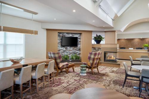 a dining room with a table and chairs and a fireplace at Residence Inn Asheville Biltmore in Asheville