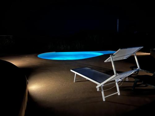 a white chair sitting in front of a swimming pool at Dammuso i Pini di Kaddiuggia (CIR19081014C224053) & Dammuso di Mena (CIR 19081014C224052 in Pantelleria