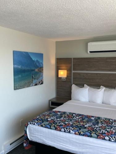 a hotel room with a bed and a painting on the wall at Americas Best Value Inn Polson in Polson