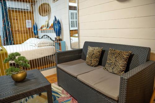 a wicker couch with pillows on a patio at Chalets Boiskanon B in Matoury