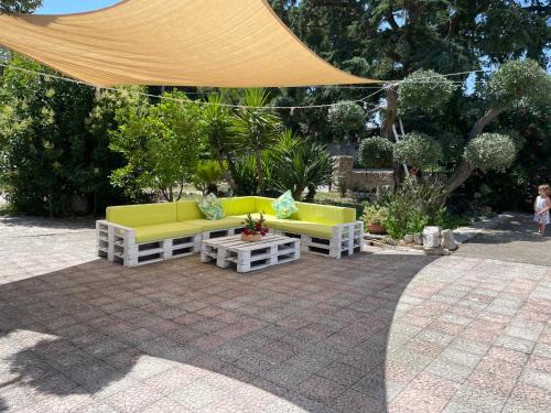 a patio with yellow and white couches and a table at Il trullo di nonno Licchio in Alberobello