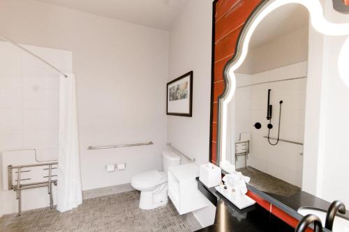 a white bathroom with a toilet and a sink at Hotel Indigo San Antonio Riverwalk by IHG in San Antonio