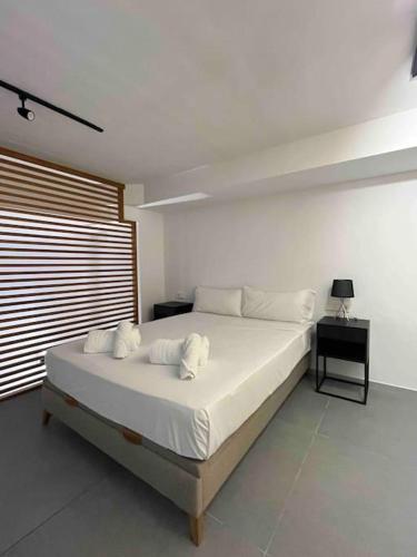 1 dormitorio con 1 cama grande con almohadas blancas en WeRentVLC - Espectacular Loft Duplex 1 hab en Valencia