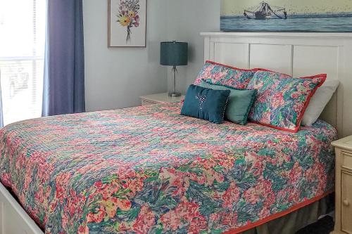 a bedroom with a bed with a colorful comforter at Driftwood Villa - 280 in Edisto Beach