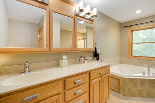 ein Badezimmer mit zwei Waschbecken und einer Badewanne in der Unterkunft Riverfront Bliss in Rice Lake Deck, Grill and Hike! in Mikana