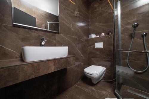 ein Bad mit einem WC, einem Waschbecken und einer Dusche in der Unterkunft Hotel Opera in Pristina