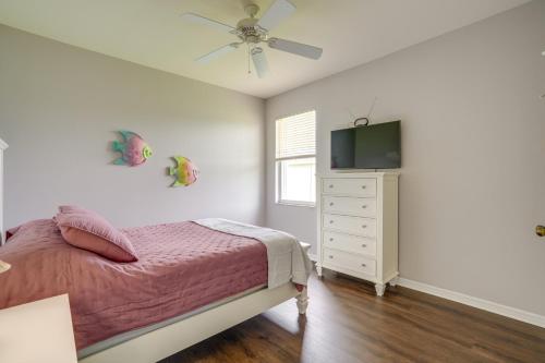 a bedroom with a bed and a dresser with a television at Sunny Fort Myers Home with Heated Pool! in Fort Myers
