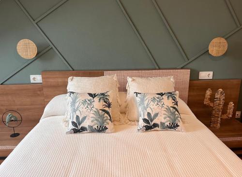 1 dormitorio con 1 cama con sábanas y almohadas blancas en Maison Villaviciosa Asturias, en Villaviciosa