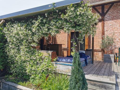 a pergola with white flowers on a patio at Surfworx Lodge in Soustons