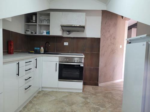 Una cocina con gabinetes blancos y una estufa. en Double Dream Vrnjačka Banja, en Vrnjačka Banja
