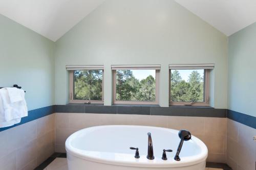 Una bañera blanca en un baño con tres ventanas. en 151 Oak Road, en Durango