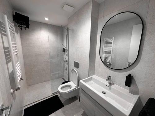 a bathroom with a sink and a toilet and a mirror at SuprStay - Belgrade Waterfront Luxury Studio in Belgrade