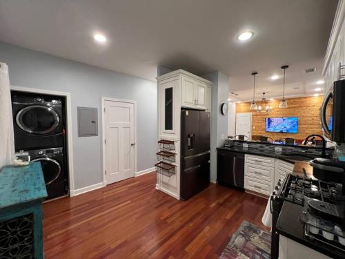 a kitchen with a black refrigerator and wooden floors at Cozy Chicago Apartment next to the River in Chicago