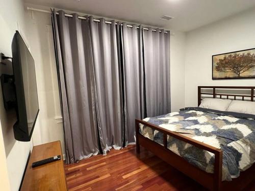 a bedroom with a bed and a large window with curtains at Cozy Chicago Apartment next to the River in Chicago