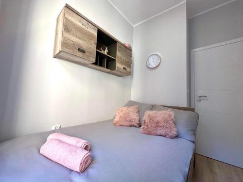 1 dormitorio con 1 cama con 2 almohadas rosas en MMRent Sparrow Room, en Gdansk